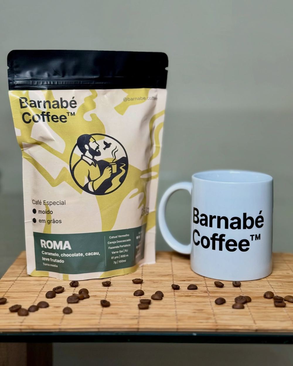 Pacote do café Roma ao lado de uma caneca Barnabé Coffee