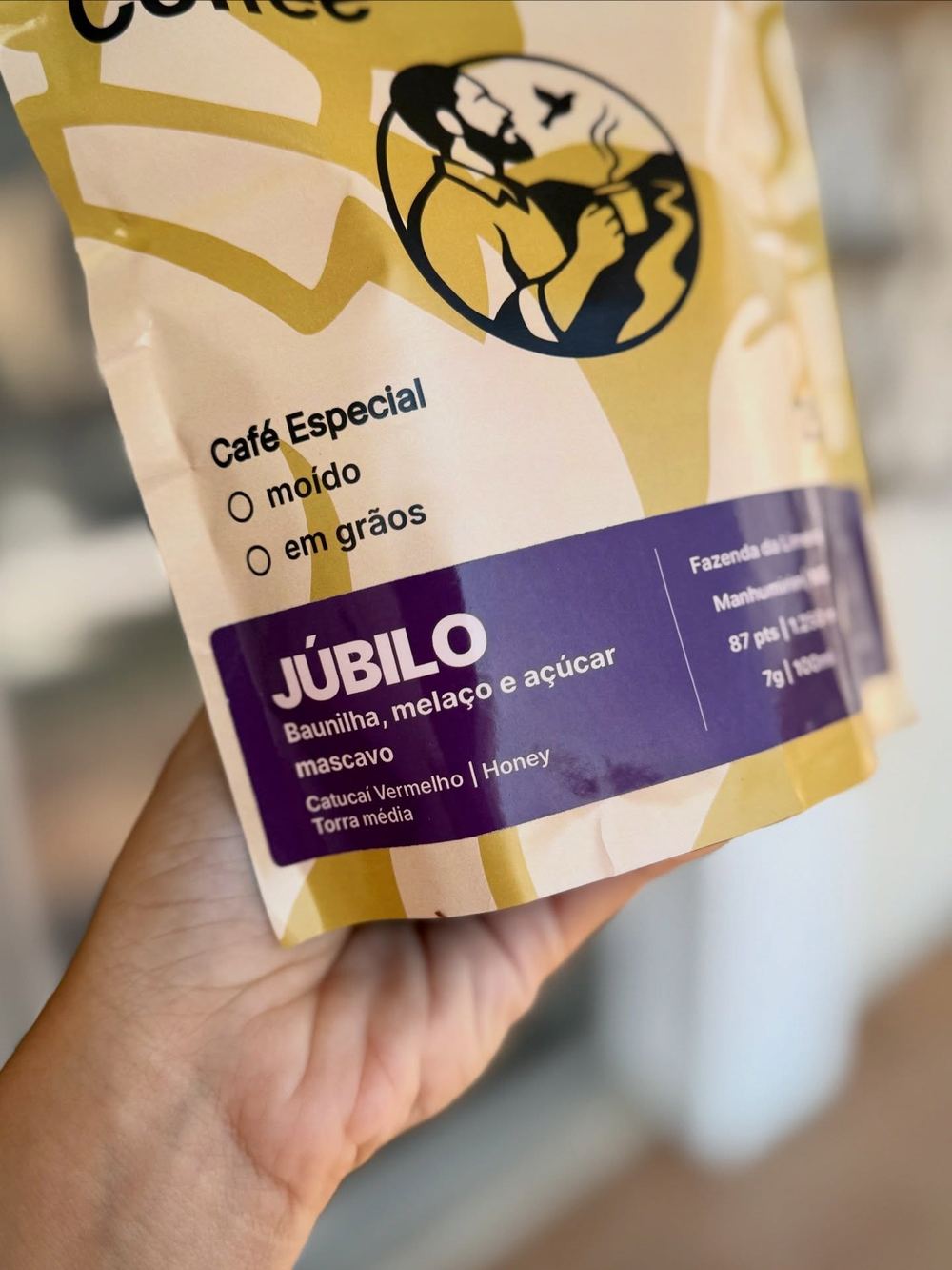 Mão segurando um pacote do café Júbilo